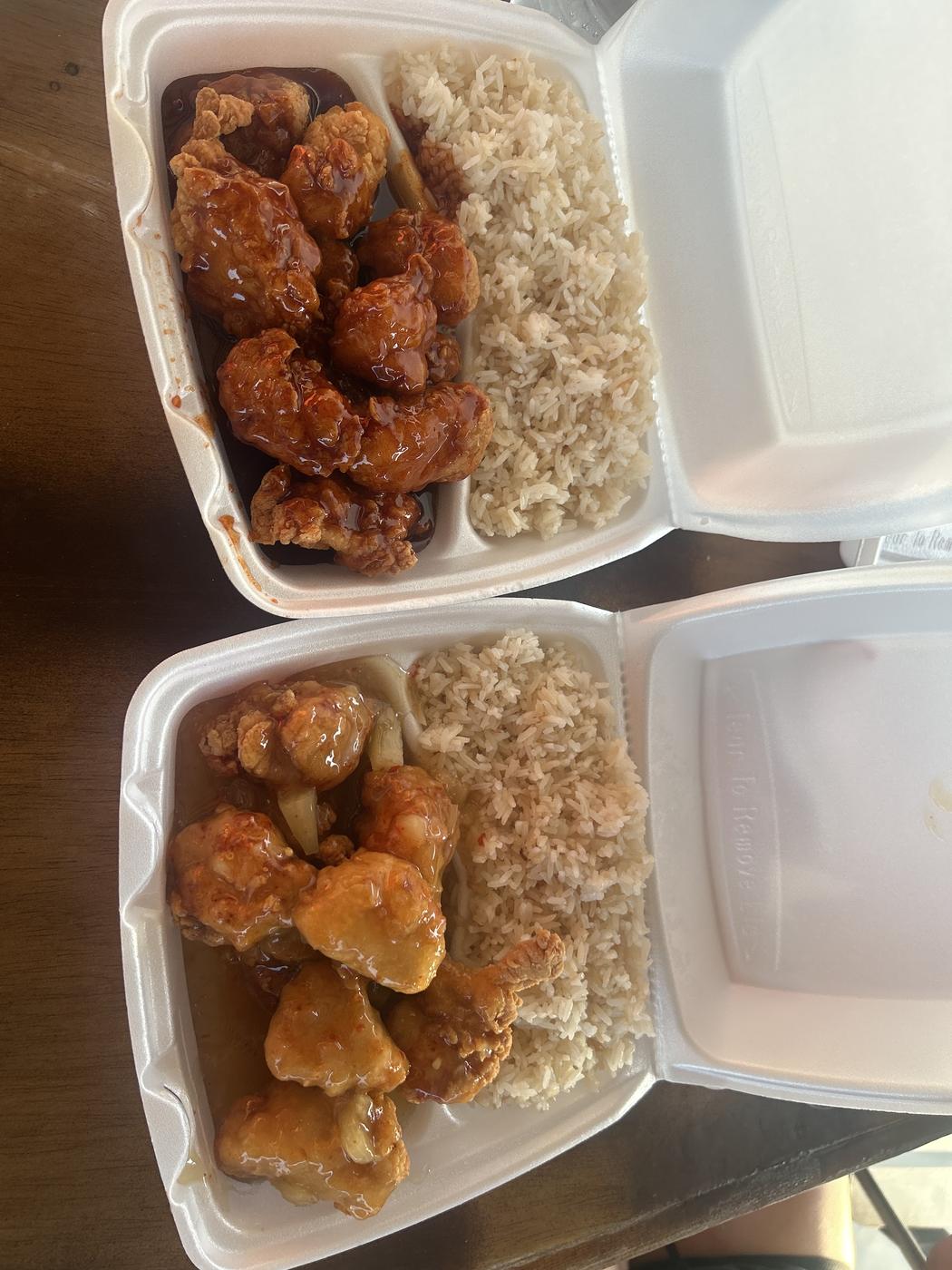Two takeout containers of fried chicken with rice
